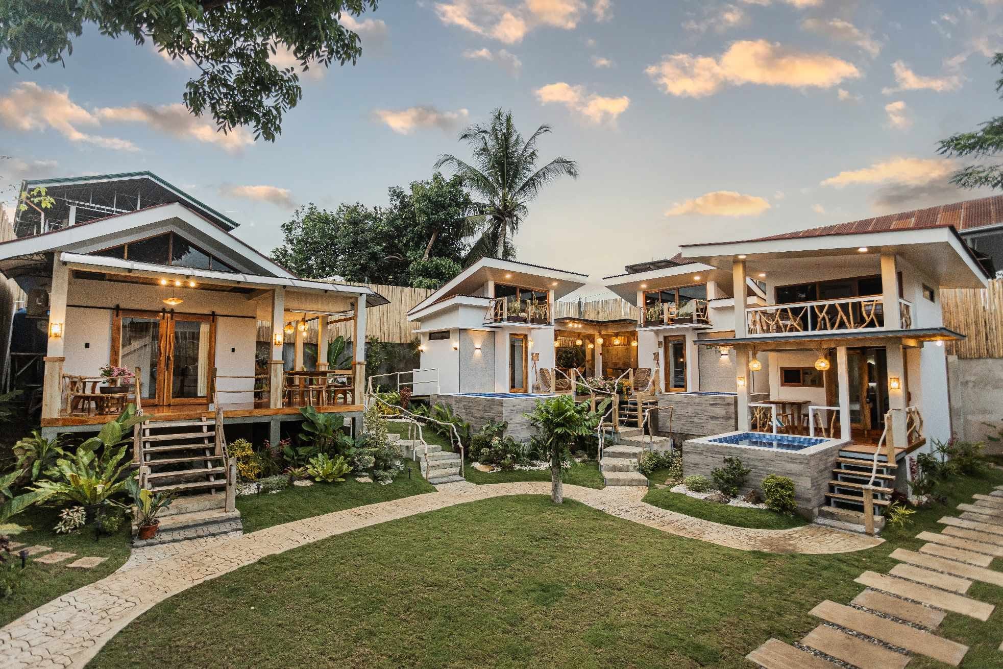 The four Casa 2455 villas around the garden lawn at golden hour